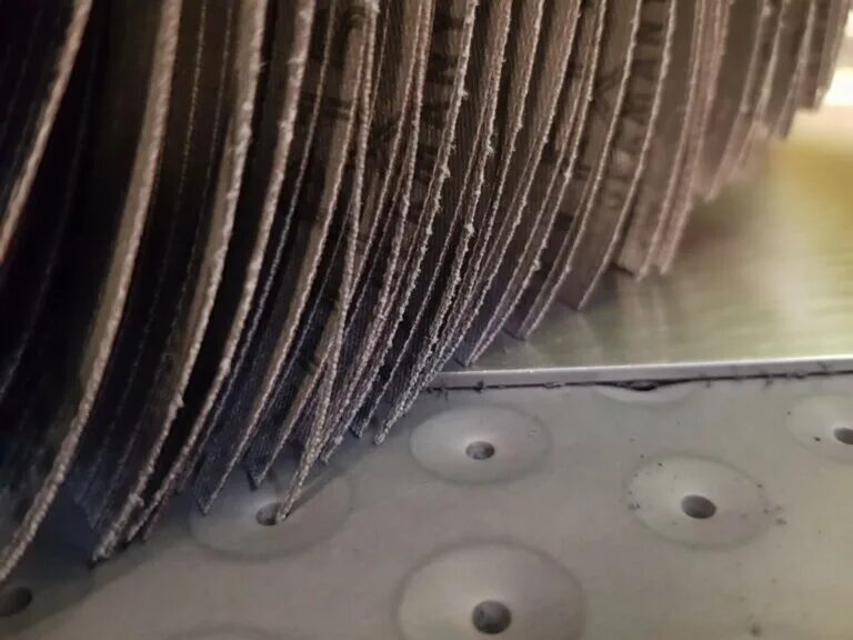 Close-up of the laser-cut abrasive lamellae on a deburring roller
