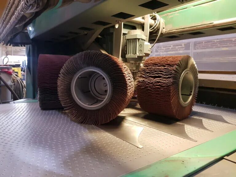 A pair of Boeck deburring rollers mounted under the FLADDER machine